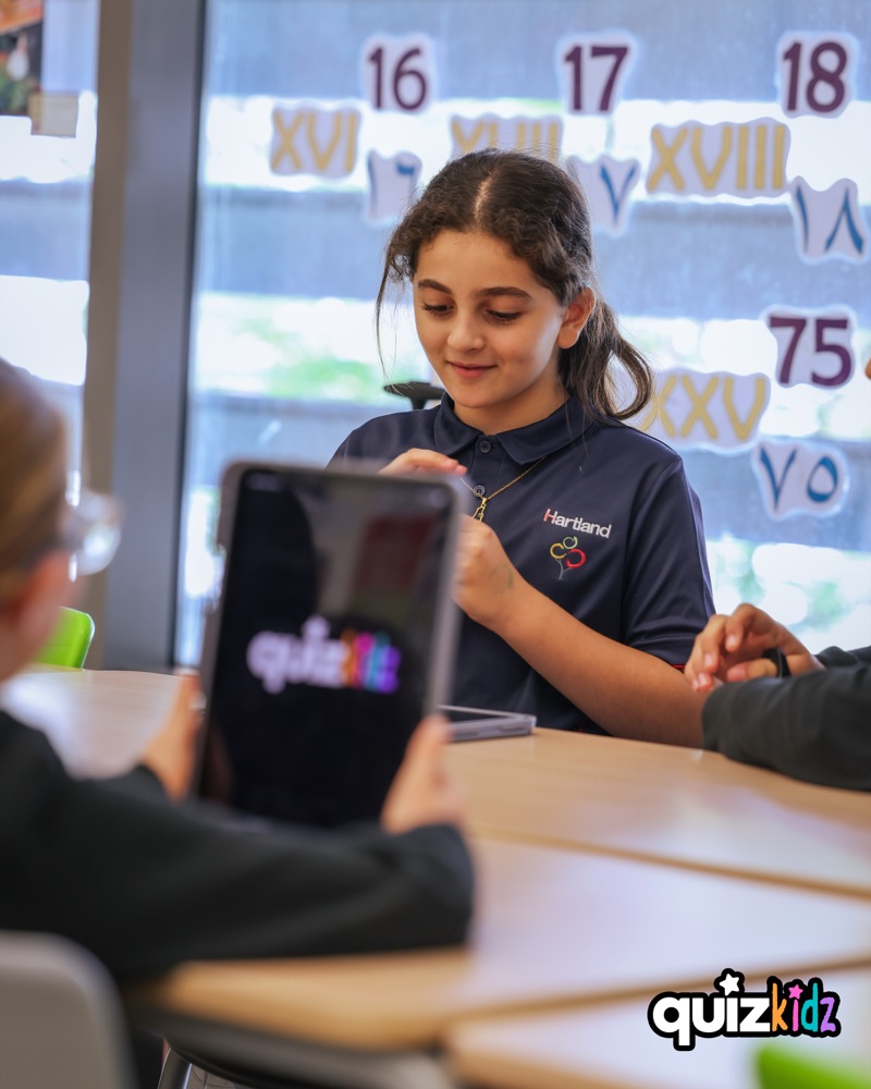 A child smiling during a QuizKidz session with a tablet